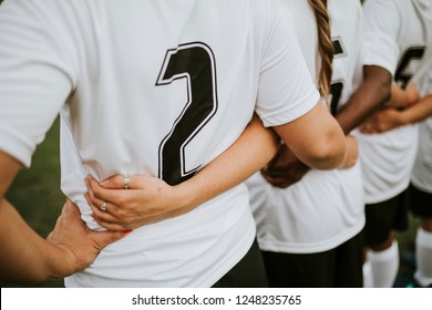 Close up of female football players huddling - Powered by Shutterstock