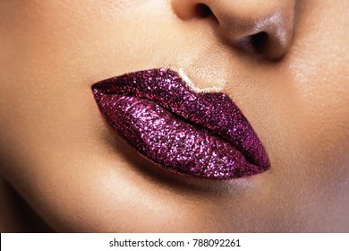 Close up of female glossy female lips with glitters
