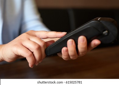 Close Up Of Female Hand Entering PIN Number Using Payment Terminal
