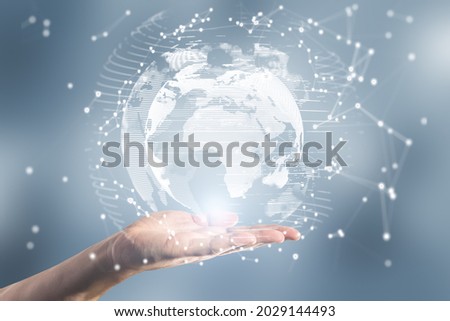 Close up of female hand holding abstract glowing polygonal globe on blurry background. Network, communication and global innoovation concept