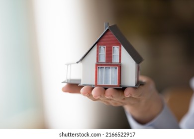 Close Up Female Hand Holding On Palm Small Cottage House Model. Real Estate Purchase, Sell New Property, Construction Company Make Profitable Commercial Offer To Client, Ownership, Bank Loan Concept