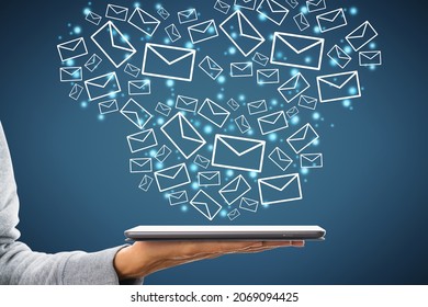 Close up of female hand holding tablet with creative drawn email icons on blue background. Business, technology, communication and e-mail marketing concept - Powered by Shutterstock