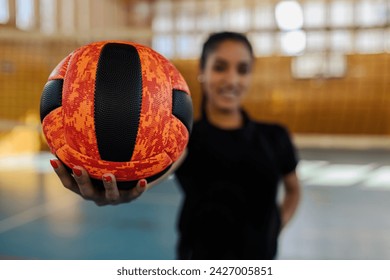 Close up of female hand holding a volleyball on court and showing it to the camera. Close up of a teenage female volleyball player standing on court during training and showing a ball to the camera. - Powered by Shutterstock