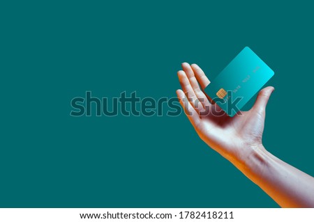 Close up female hand holds levitating template mockup Bank credit card with online service isolated on green background