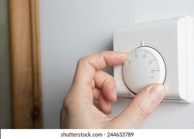 Close Up Of Female Hand On Central Heating Thermostat - Shutterstock ID 244633789