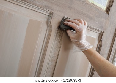 Close Up Female Hand Painting An Old Door Inside A House With A Brown Patina