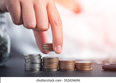 Close up female hand stacking coins and counting on the table. concept of Saving money, economy, investment, growing business and wealth. - Powered by Shutterstock