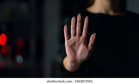 Close Up Of Female Hand Touching Glass Wall Indoors. Young Woman Holding Hand On Glass Surface. Unknown Girl Leaving Handprint Of Right Hand On Transparent Wall.