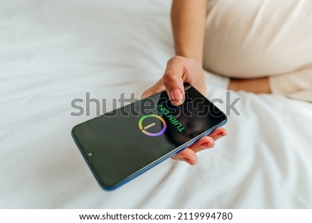 Close up of female hand turning off the smartphone