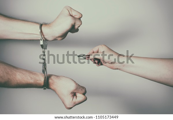 女性の手の接写 男性の手錠の鍵を外し 解放する 離婚のコンセプト の写真素材 今すぐ編集