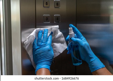 Close up of female hand using wet wipe and alcohol sanitizer spray to clean an elevator push button control panel.Disinfection ,cleanliness and heathcare,Anti Corona virus (COVID-19). Selective focus. - Powered by Shutterstock