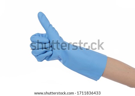 
close up female hand wearing blue latex cleaning gloves with thumbs up on white isolated studio background