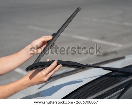 Close up of female hands changing windshield wipers. 