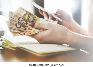 Close up of female hands counting euro bills and using smart phone, businesswoman counts money and typing on cellphone - Powered by Shutterstock