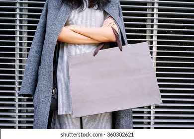 Close up female hands holding a blank paper bag with empty space for your text or logo