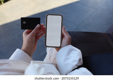 Close Up Of Female Hands Holding Credit Card Mockup And Blank Phone Screen On The Street, Online Shopping, Place For Your Text.