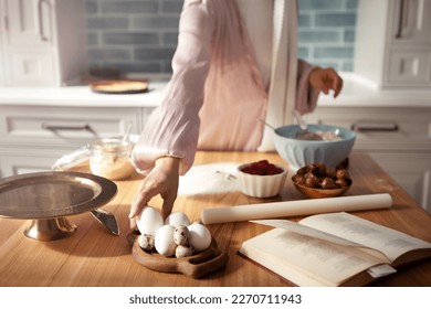 Close up female hands kneading dough in kitchen. Woman bakes pie or cake at home - Powered by Shutterstock