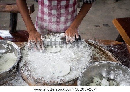 close up of female hands kneading dough