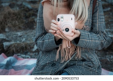 Close up of female hands with pink picture camera  Instax 