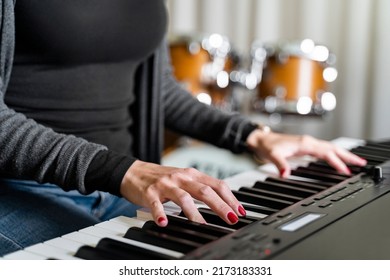 Close Up Female Hands With Red Manicure Of Young Woman Playing Digital Keyboard Electronic Piano Alone Near Drums In Music Studio, School Or Stage On Concert Or Event. Hobby Weekend Activity, Study