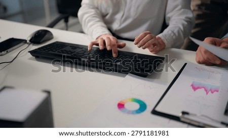 Close up female hands typing computer keyboard male with papers diagram stats Caucasian smiling business woman using pc with unrecognizable men colleagues helping three multiethnic office managers