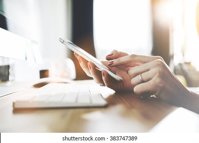 Close up of female hands using modern smartphone at office, businesswoman typing on cellphone text message, woman's hands using technology in interior, filtered image