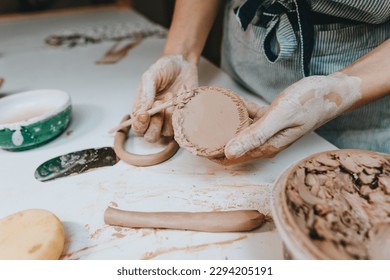 Close up of female hands working with clay in a workshop. Selective focus. - Powered by Shutterstock