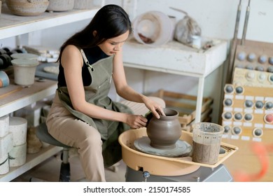 Close Up Of Female Hands Working On Potters Wheel,asian Female Sculpture Woman Shaping Mold Small Vase Bowl Clay On Potter's Wheel At Home Studio Workshop Art And Creation Hobby Concept