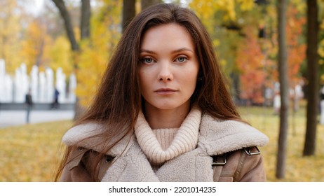 Close Up Female Headshot Portrait Beautiful Serious Caucasian European Appearance With Flawless Clean Skin Woman Brunette Millennial 20s Girl Upset Offended Lady Stand In Autumn Park Outdoors Posing