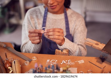 Close Up Of Female Jeweller At Bench Checking Ring She Is Working On In Studio - Powered by Shutterstock