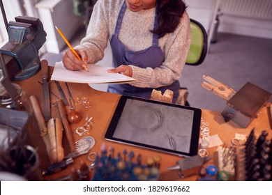 Close Up Of Female Jeweller Looking At Ring Design On Digital Tablet In Studio - Powered by Shutterstock