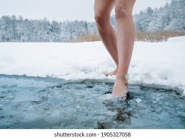 Close up of female legs getting into ice cold water