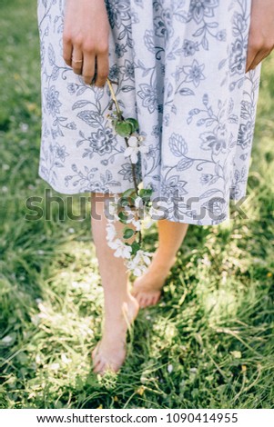 close up of female legs walking on green grass field . barefoot foot. woman's crossed legs walking on agriculture wheat field. Light step barefoot on the soft summer grass. springtime season