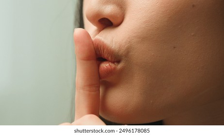 Close up female mouth Asian chinese korean japanese girl unrecognizable woman showing hush lips secret silence quite secrecy confidential mysterious whisper silent hand gesture face details in studio - Powered by Shutterstock