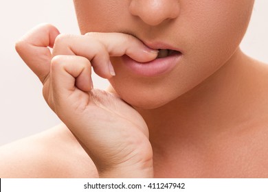 Close up of a female mouth biting her fingers - Shutterstock ID 411247942