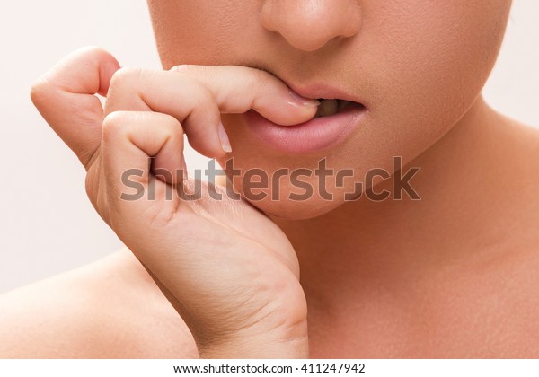 女の口の接写が彼女の指を噛んでいた の写真素材 今すぐ編集