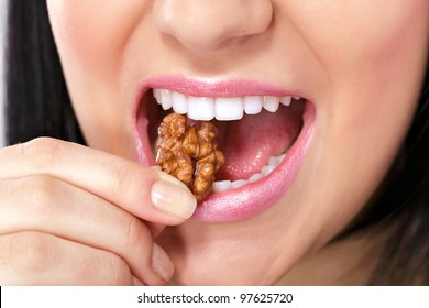 Close up of female mouth eating nut