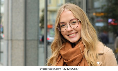 Close up female outdoors smiling laughing Caucasian woman smile looking at camera girl blonde model with healthy white teeth happy lady with glasses posing on street in city attractive student outside - Powered by Shutterstock