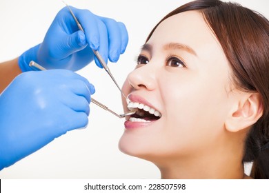 Close up of female patient having  teeth examined by dentist - Shutterstock ID 228507598