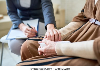 Close up of female psychologist holding hand of senior woman during therapy session, copy space - Shutterstock ID 1038930250