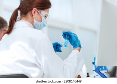 Close Up .female Scientist Looking At Test Tube .