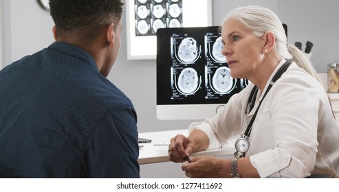 Close Up Of Female Senior Doctor Explaining Ct Scans To Patient After Concussion