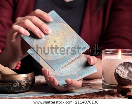 A close up of a female tarot reader shuffling tarot cards 
