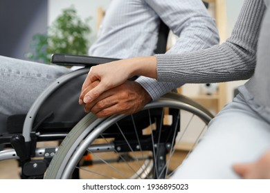 Close up of female touching hand of disabled man in wheelchair for support - Powered by Shutterstock