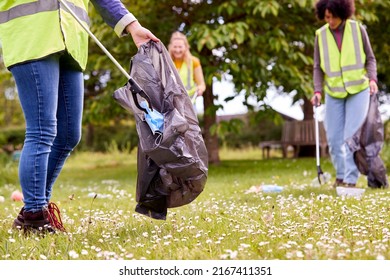 Close Up Of Female Volunteers Picking Up Litter In The Countryside - Powered by Shutterstock