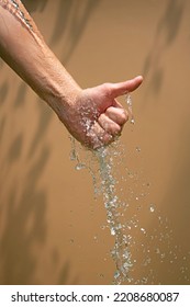 Close Up Of A Female Wet Hand With Water Gliding Over It On A Be