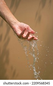 Close Up Of A Female Wet Hand With Water Gliding Over It On A Be