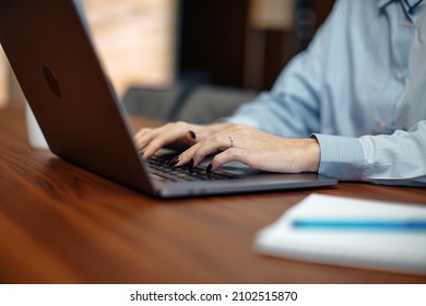 Close up female working on computer laptop typing on keyboard, writing e-mail. E-learning, online education concept - Shutterstock ID 2102515870