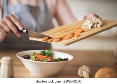 Close Up Of Females Hands Holding Cutting Board With Cut Veggies