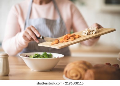 Close Up Of Females Hands Holding Cutting Board With Cut Veggies